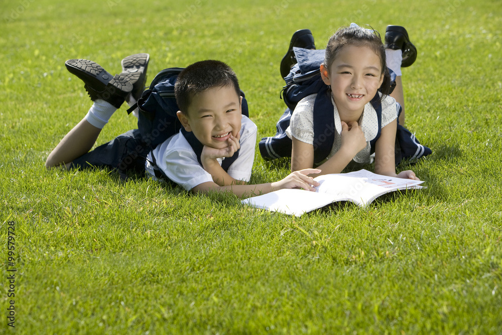 小学生在草地上读书