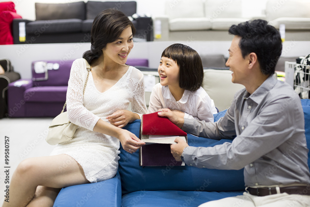 Happy family shopping for sofa in furniture shop