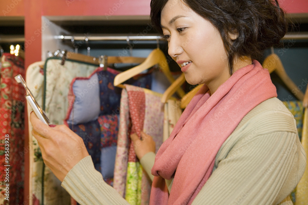 年轻女子在商店用手机打字