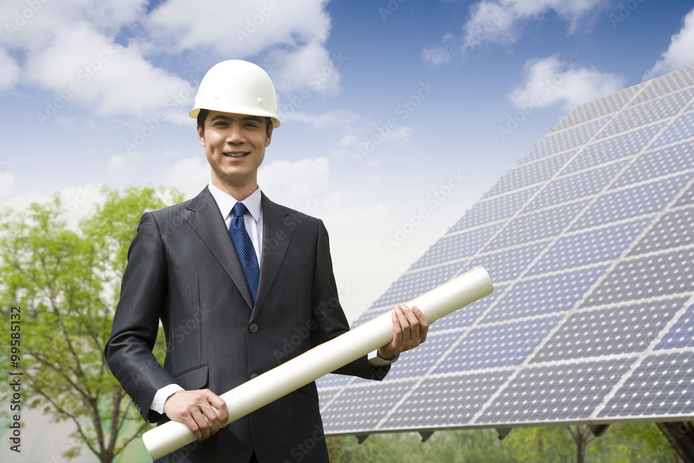 Portrait of an engineer in front of solar panels