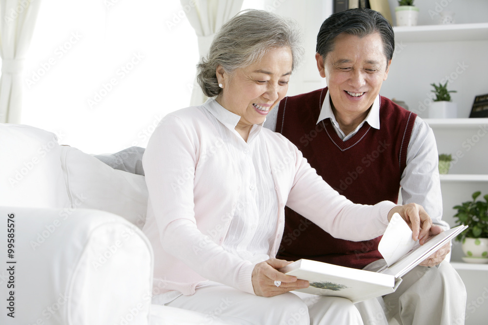 Senior Chinese couple looking at photo album