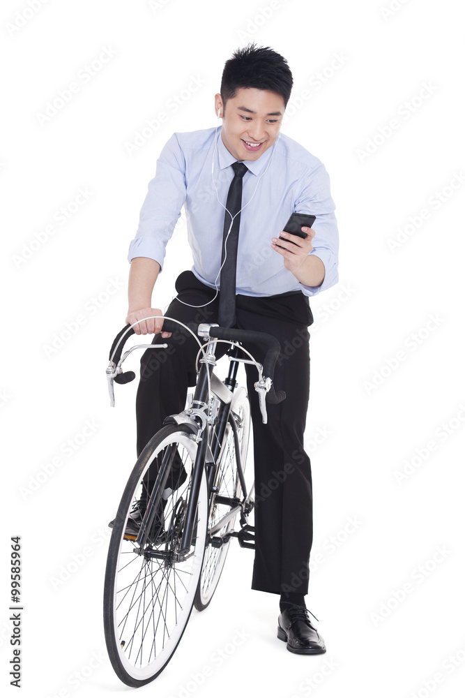 Young businessman checking smart phone on bike