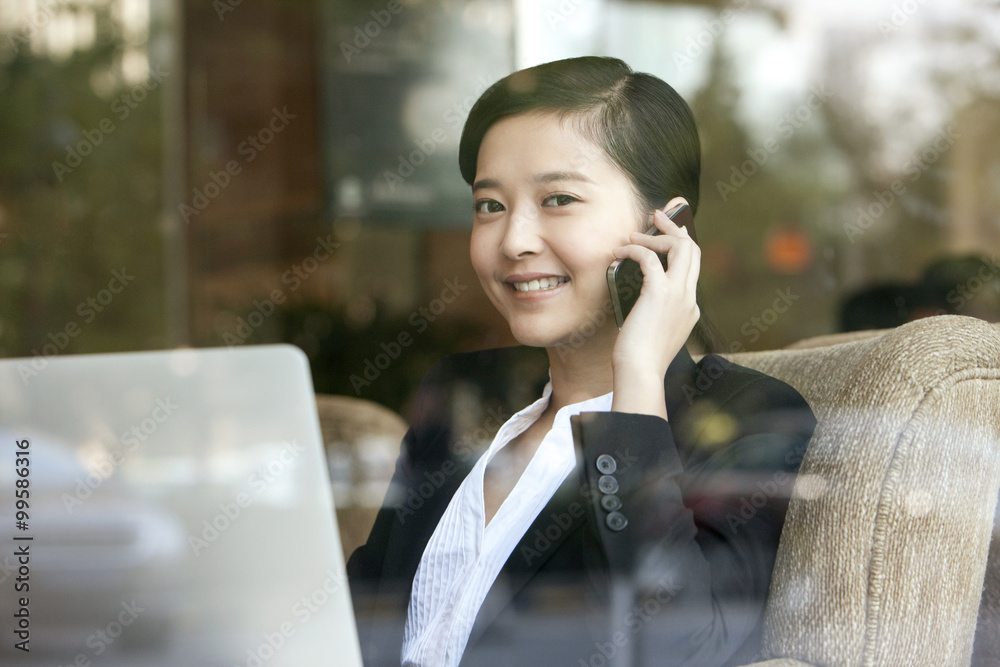 Joyful businesswoman on the phone in cafe