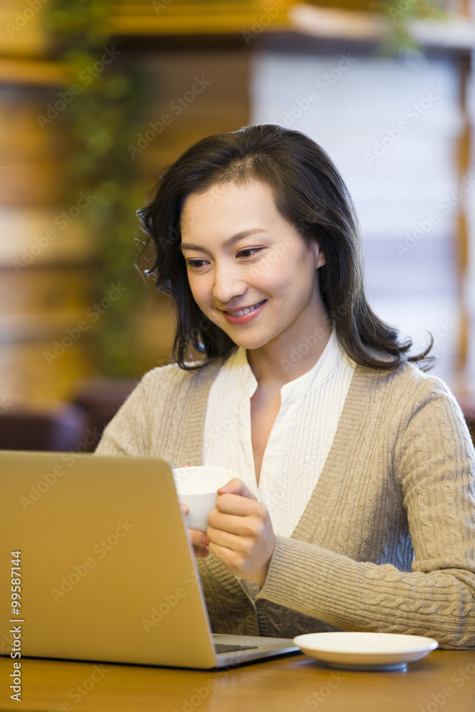 Young woman using laptop in cafe