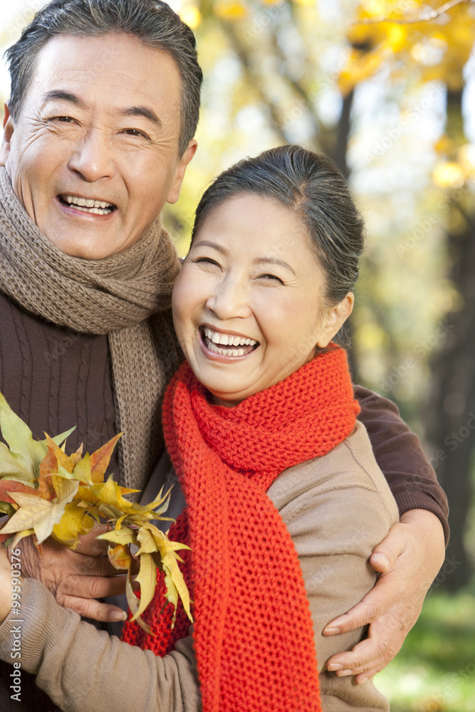 Senior couple with a collection of leaves in Autumn