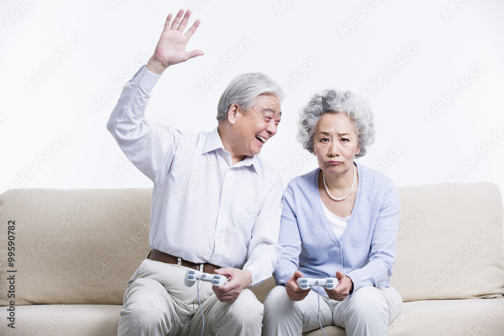 Senior couple playing video game in living room