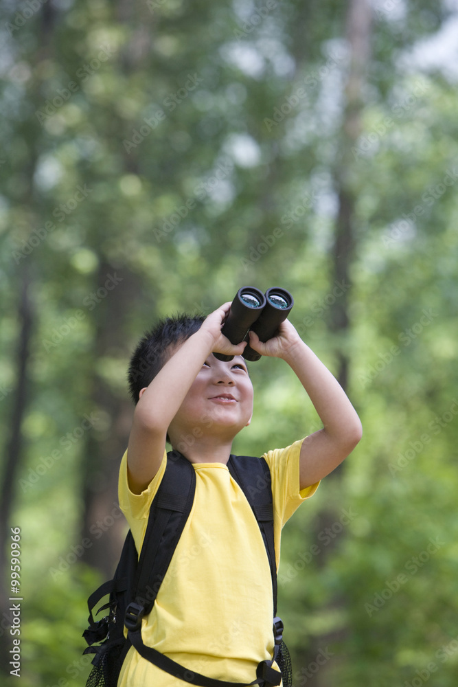 Young boy looking through binoculars