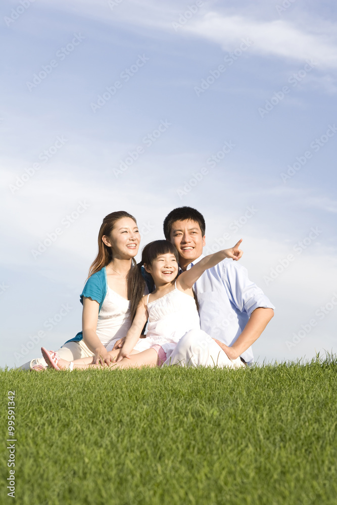 Family of three sitting on the grass