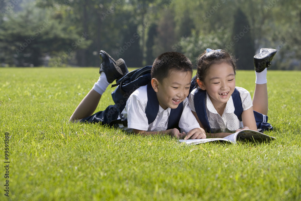 小学生在草地上读书