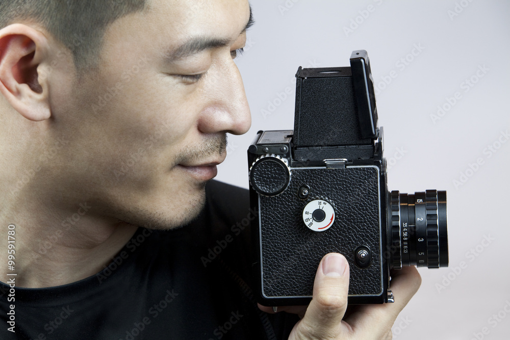 Young man taking photos with old-fashioned camera