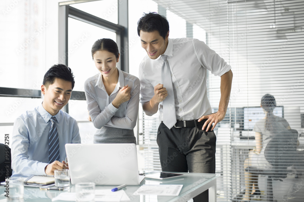 Young business people using laptop in office