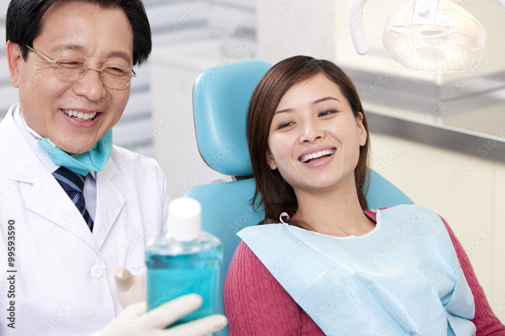 Dentist introducing mouth wash to patient