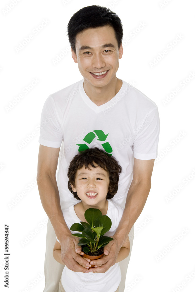 Little boy with his father holding a potted plant