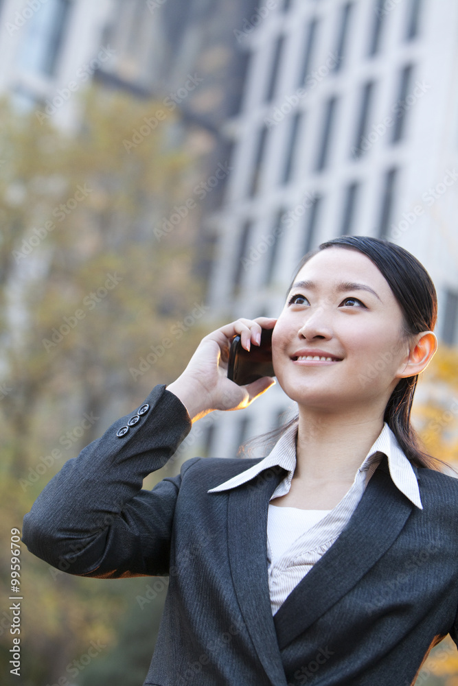 办公楼外的女商人用手机