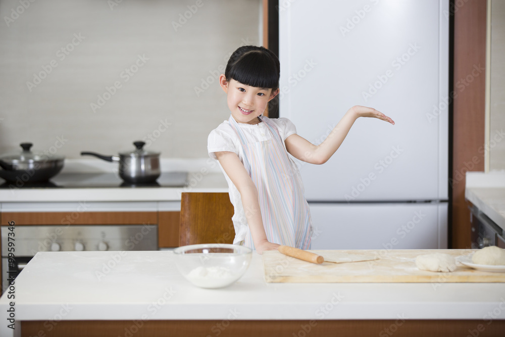 Cute girl rolling out dough