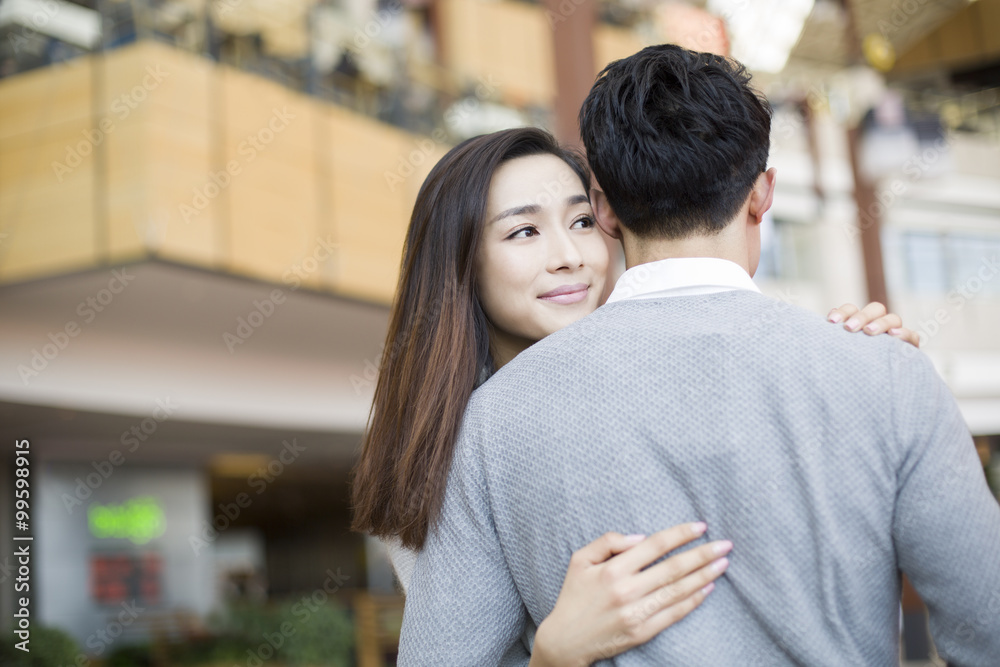 Young couple embracing in shopping mall