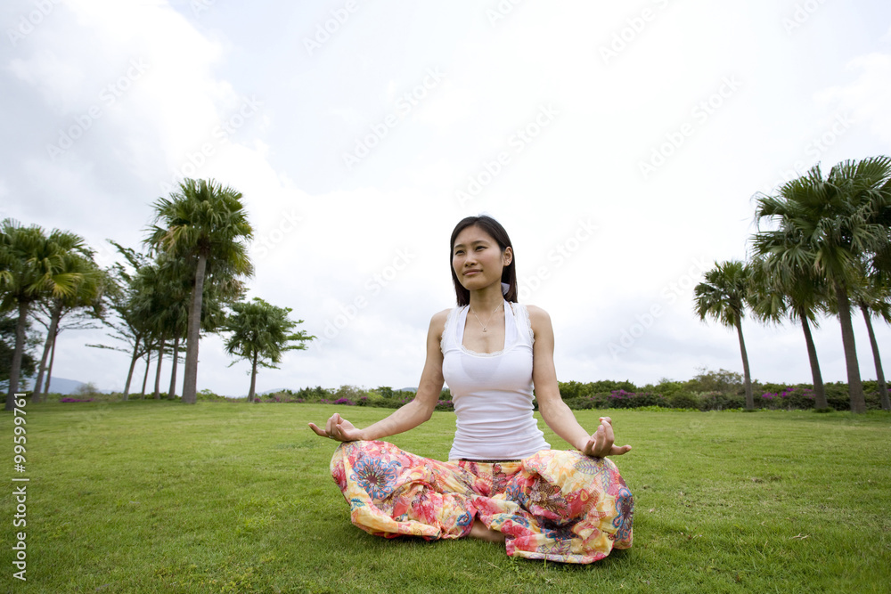 在草地上做瑜伽的年轻女人