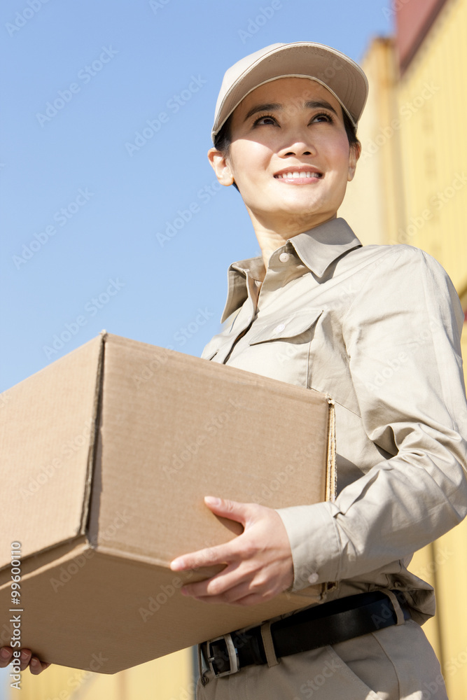 shipping industry worker carrying a cardboard box