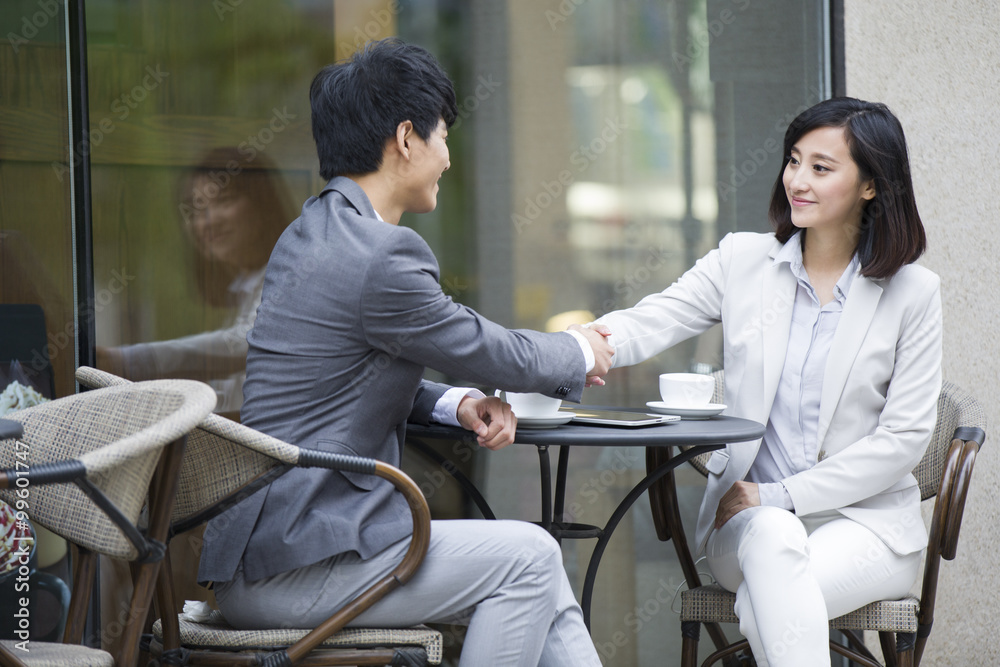 Two business person sitting at outdoor sidewalk café