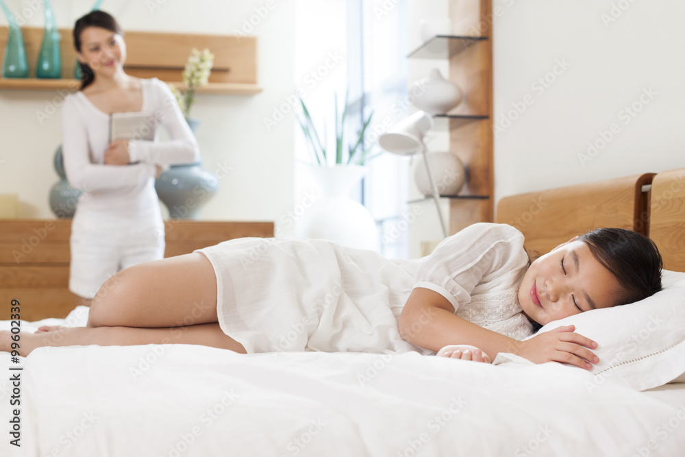 Mother looking at sleeping daughter