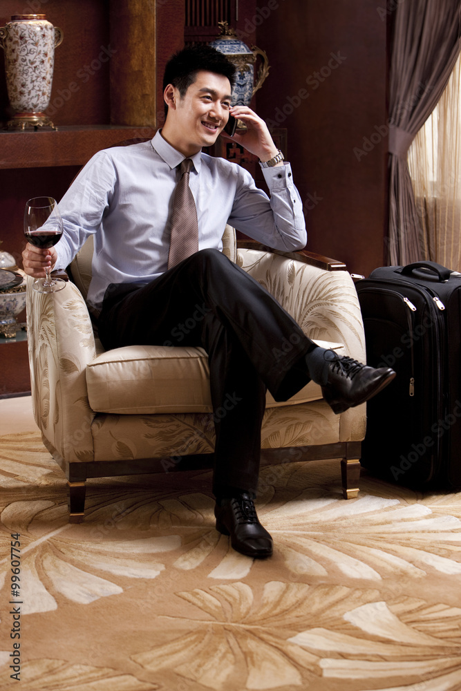 Young businessman using mobile phone in hotel