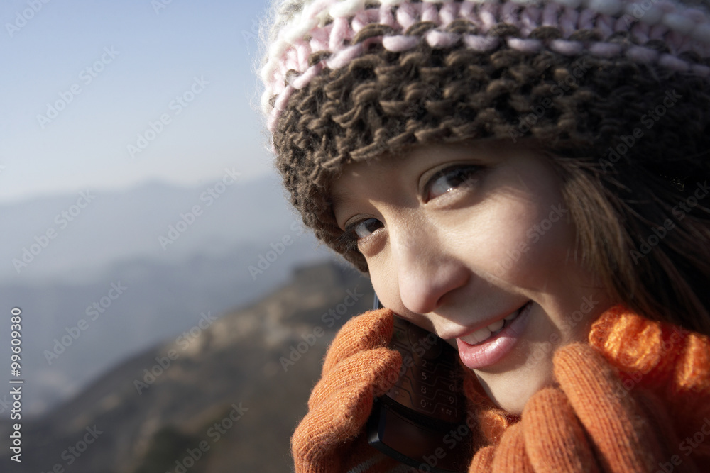 Young Woman On The Great Wall Of China, Talking On Her Cellphone