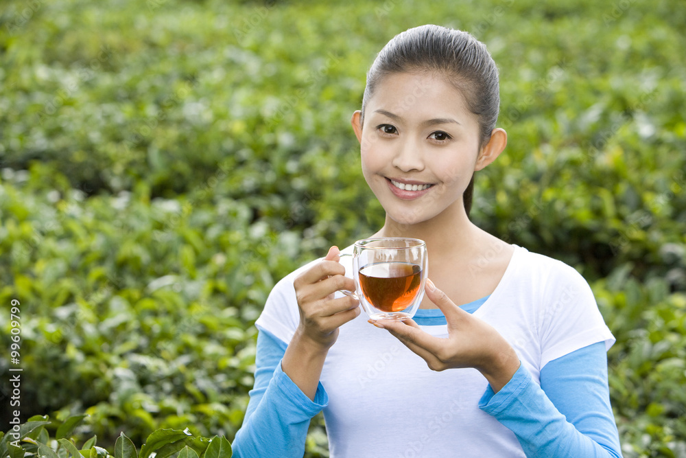 Young Woman Drinking Tea in a Tea Field