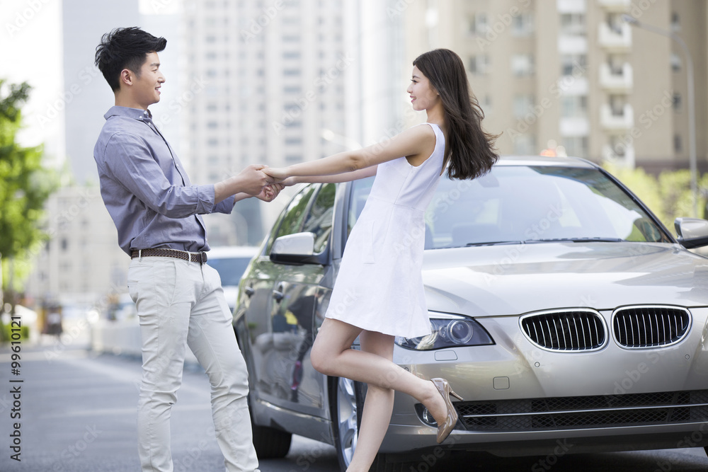 Happy young couple and car