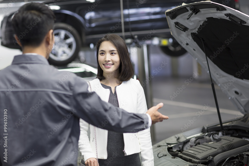 Auto mechanic talking with car owner