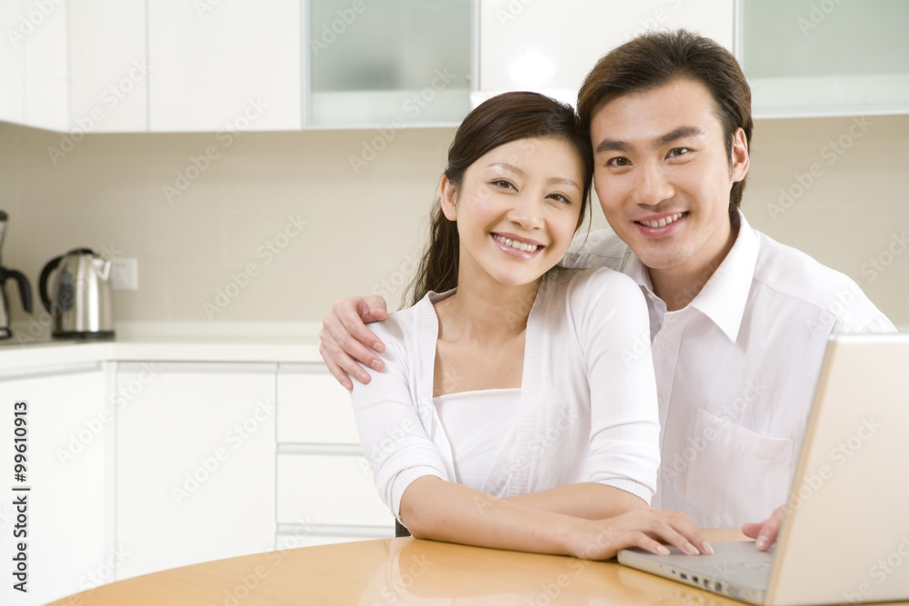 Young couple using a laptop at home