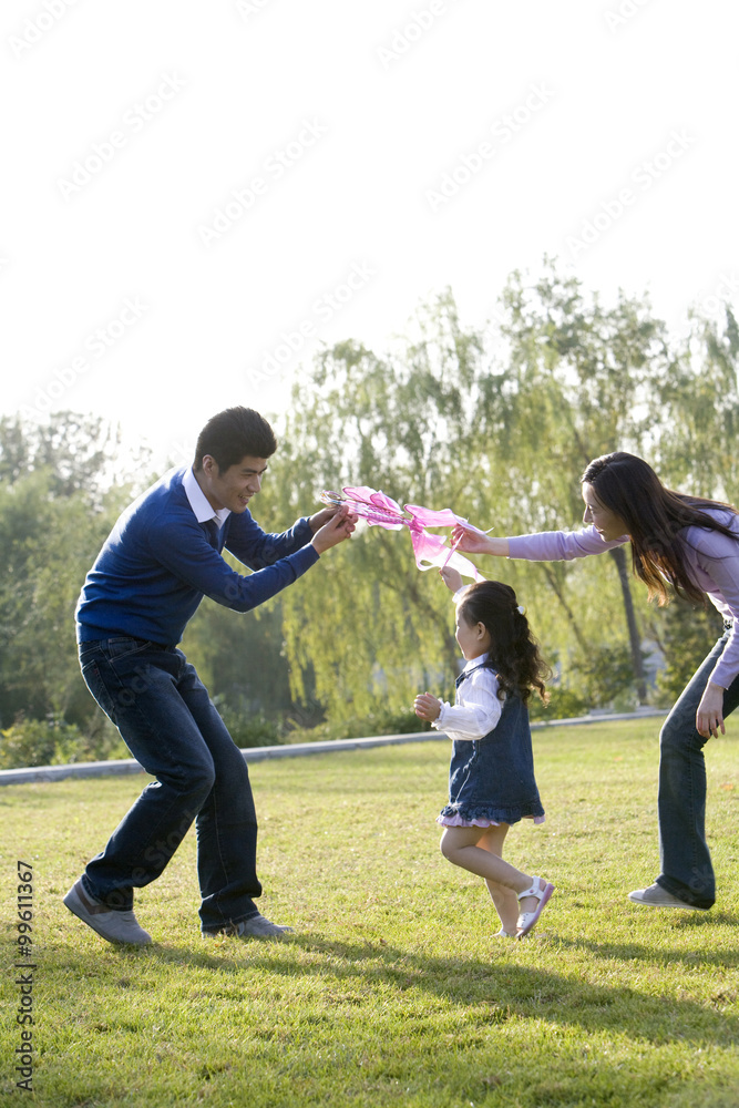 Young family flying a kite in the park