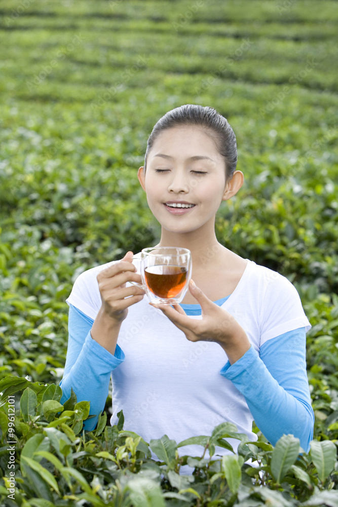 年轻女子在茶园喝茶