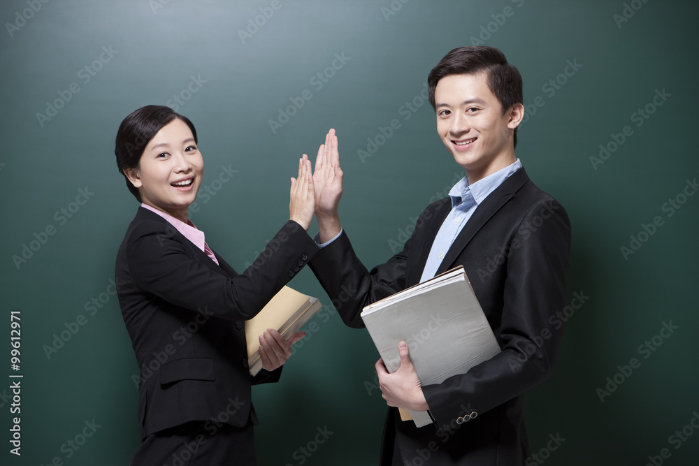 Professional male teacher and female teacher doing high-five