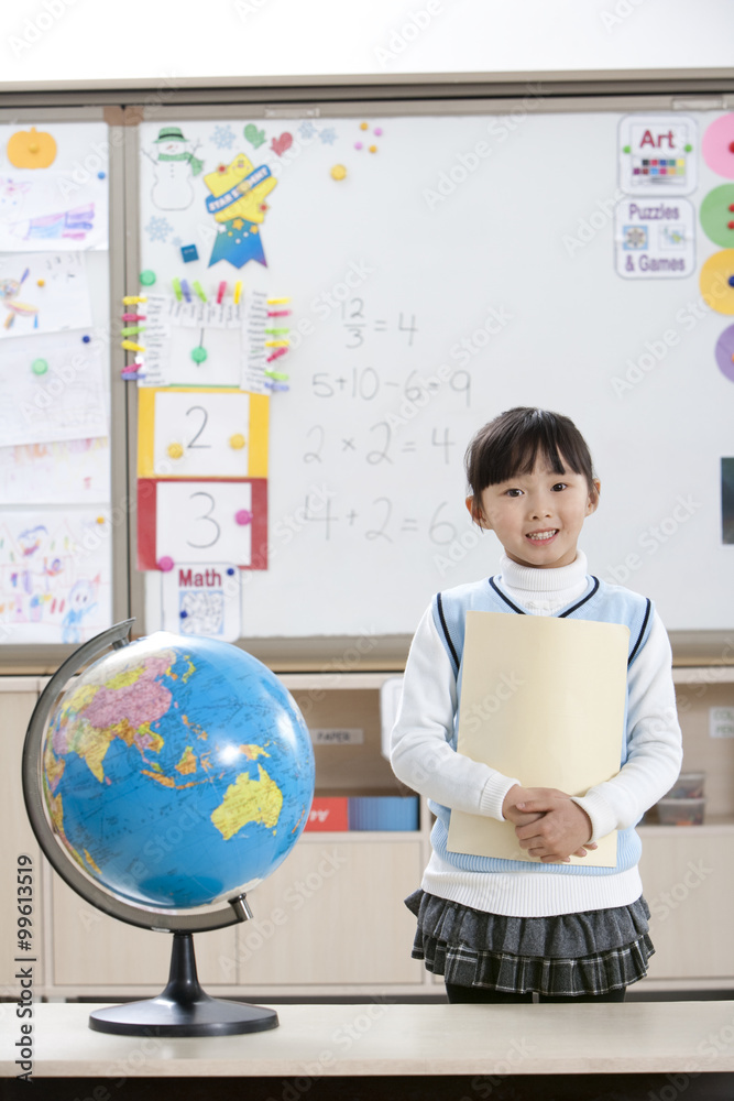 Young girl holding a folder in a classroom