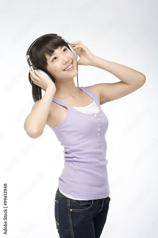 Smiling young woman listening to music on headphones