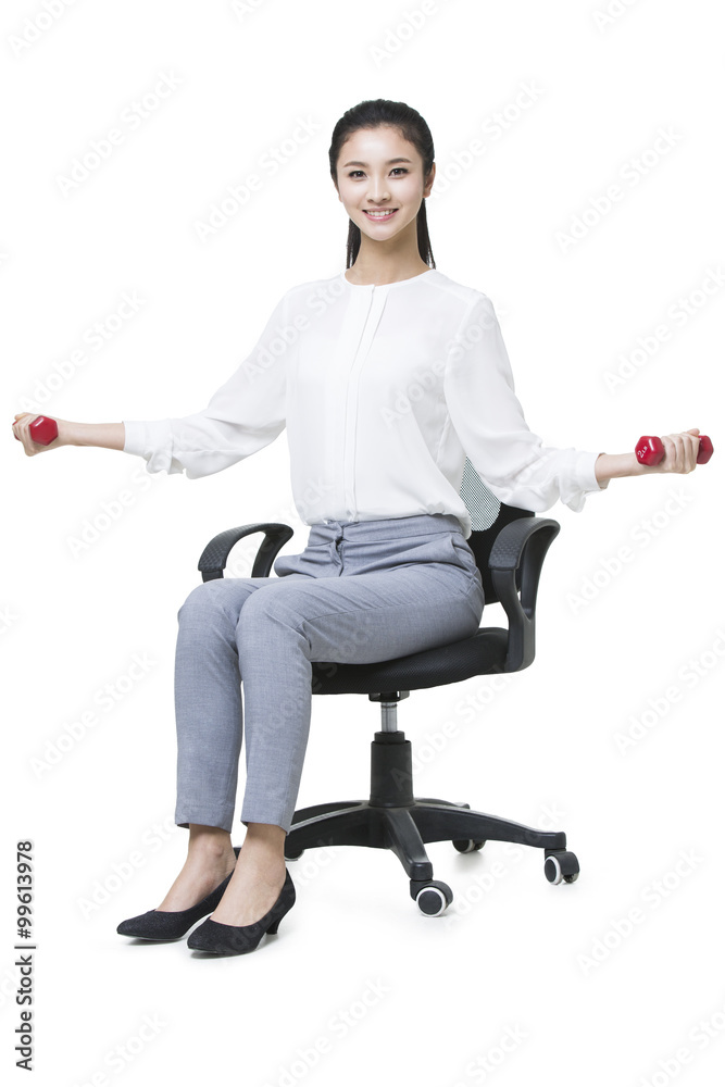 Young businesswoman lifting weights