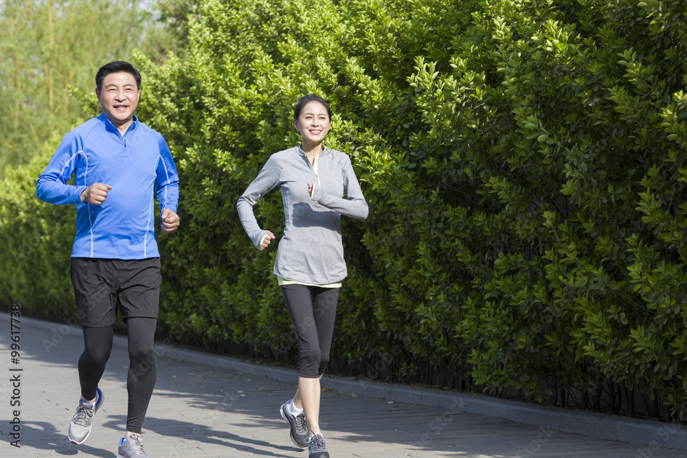 Happy mature couple running in park