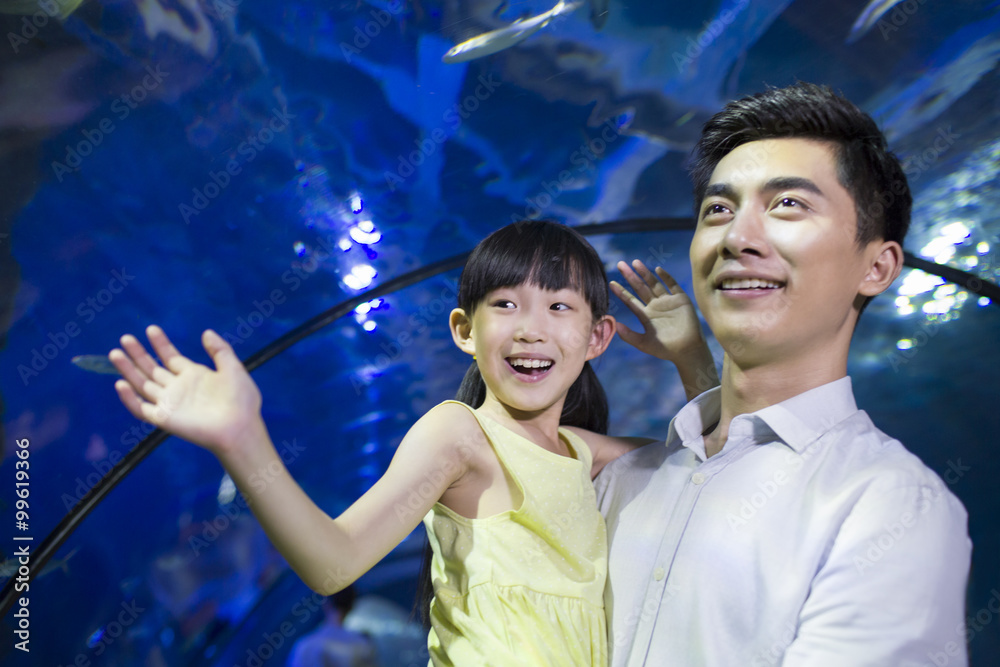 Young father and daughter in aquarium