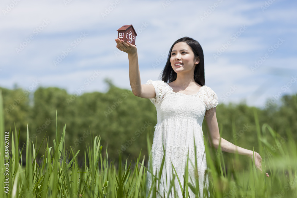 Young woman with toy house