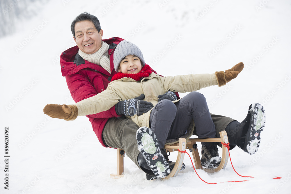 爷爷和孙子在雪橇上滑行