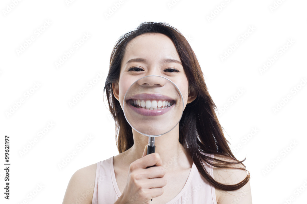 Young woman holding a magnifying glass in front of her mouth