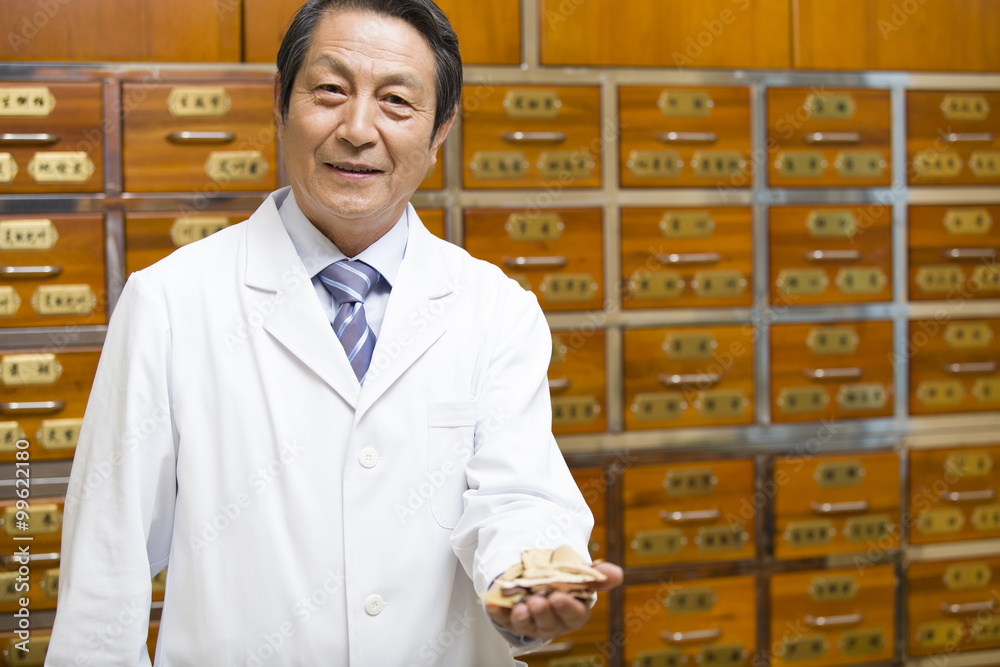 Senior doctor with various medicinal herbs