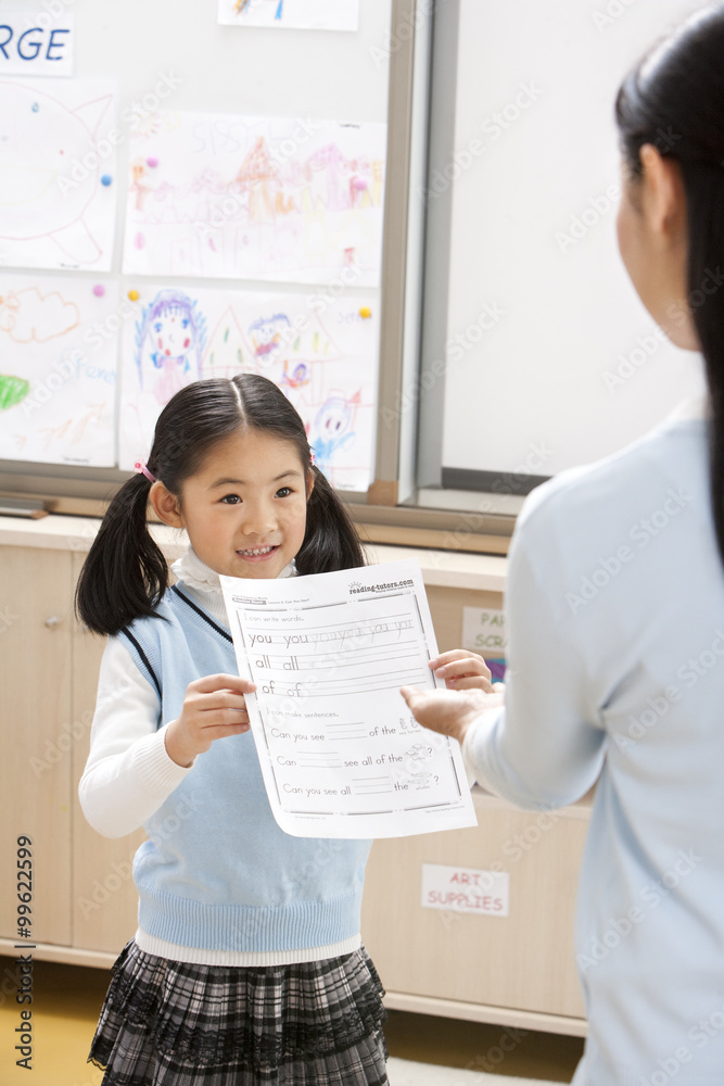 兴奋的年轻女孩向老师展示作品