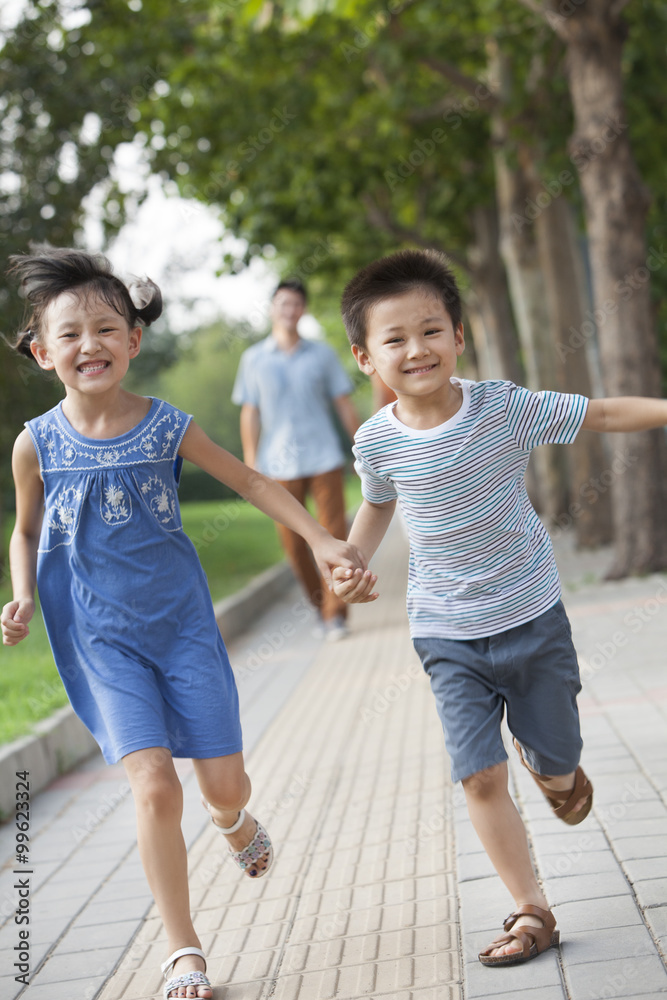 快乐的兄弟姐妹牵手奔跑