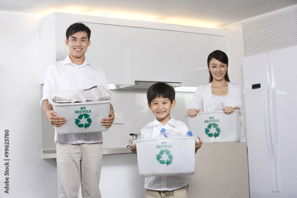 Family holding recycling boxes in kitchen