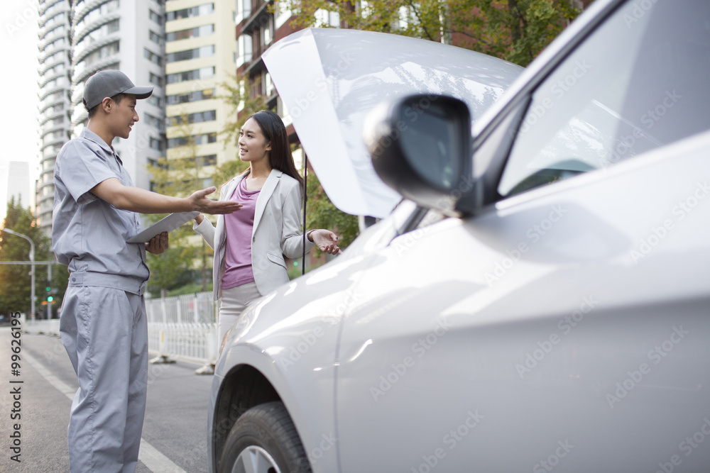 Auto mechanic talking with car owner