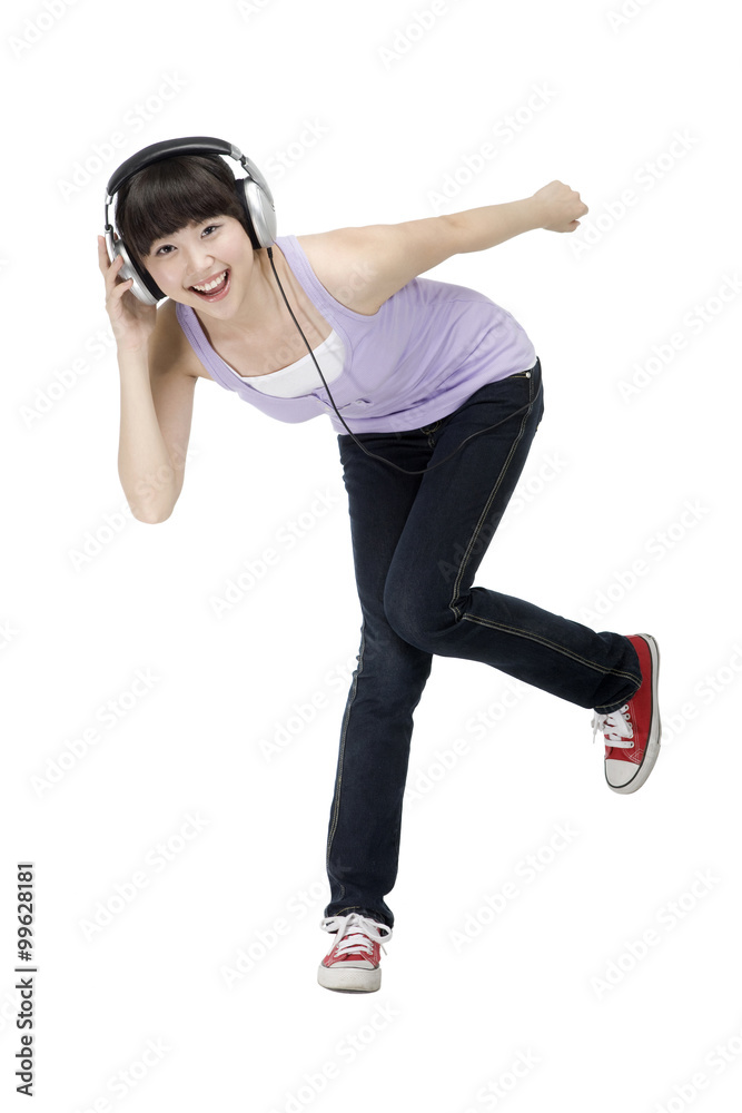 Smiling young woman listening to music on headphones