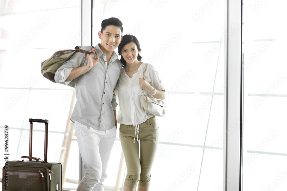 Young couple at the airport with luggage