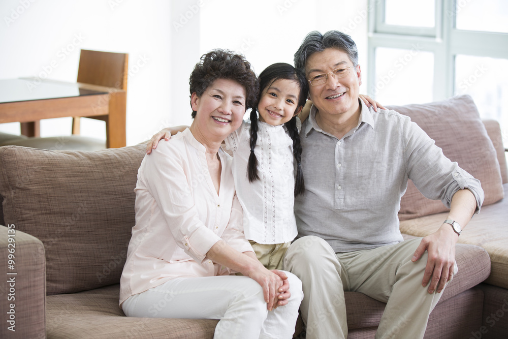 Happy girl with grandparents in living room