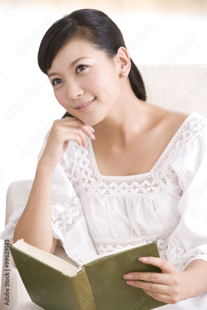 Asian woman reading on a sofa